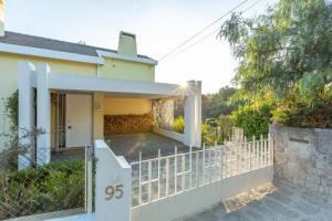 una casa blanca con una puerta y una valla en Estoril House en Estoril