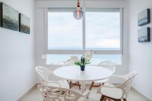 Skol Sea Views Apartments في مربلة: غرفة طعام بيضاء مع طاولة بيضاء وكراسي