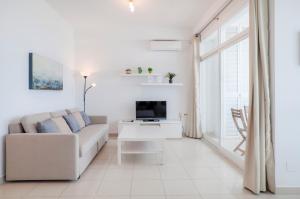 Skol Sea Views Apartments في مربلة: غرفة معيشة بيضاء مع أريكة وتلفزيون