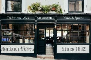 un magasin devant un restaurant avec des portes ouvertes dans l'établissement Star & Garter, à Falmouth