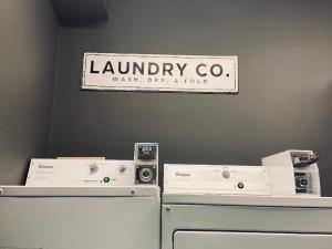 a laundry room with two machines and a sign on the wall at University Inn Duke in Durham