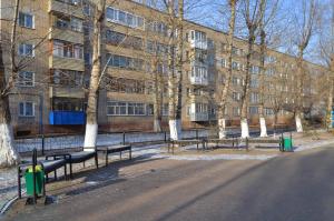 una fila de bancos frente a un edificio en 1 комнатные апартаменты на Садуакасова 24, en Kokshetau