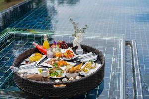 a tray of food on a table next to a swimming pool at Banyan Tree Phuket in Bang Tao Beach