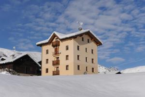 a building with a snow covered roof in the snow at Appartamenti Lumaca in Livigno