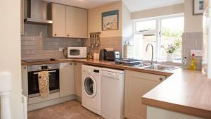 a kitchen with a washing machine and a sink at Lavender Cottage in Lyme Regis
