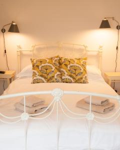 a bedroom with a white bed with towels on it at Lavender Cottage in Lyme Regis