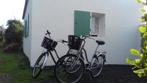 duas bicicletas estacionadas ao lado de um edifício branco em le pied marin em Ker Pierre Borny