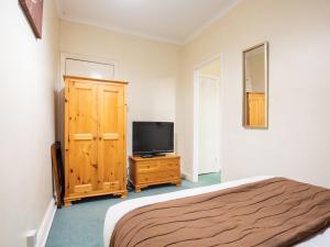 1 dormitorio con cama y vestidor con TV en Wincham Hall Hotel en Northwich