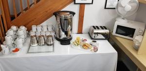 a table with a blender and cups on it at Redwings Lodge Dunstable in Dunstable