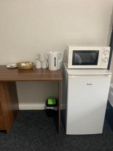 a microwave on top of a refrigerator next to a table at Hagley Hotel in Birmingham