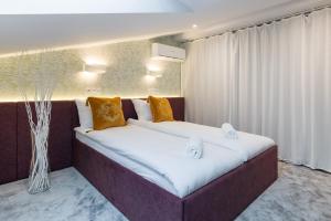um quarto com uma cama grande e almofadas laranja em DELUXE in CRACOW - OLD TOWN & CRACOW KAZIMIERZ em Cracóvia