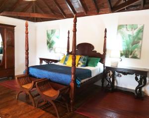 1 Schlafzimmer mit einem Himmelbett und 2 Stühlen in der Unterkunft Rural Rugama in Puerto del Rosario