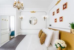a bedroom with a bed with white walls and a chandelier at Luxury 2 Bedroom 2,5 Bathroom - Louvre & Notre Dame in Paris
