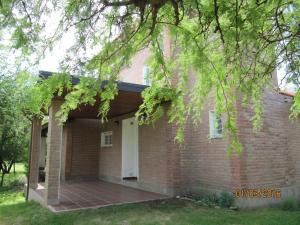 a brick house with a porch and a white door at Ayres Serranos in Merlo
