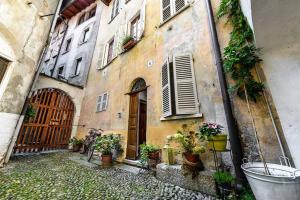 an old building with potted plants on the side of it at Al vicolo del Gallo APPARTAMENTO in Varallo