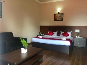 a bedroom with a large bed with red pillows at Velu's Resort in Gūdalūr