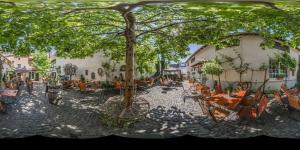 a courtyard with tables and chairs under a tree at Hotel Restaurant Alter Hof in Hofheim am Taunus