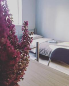 Cette chambre comprend deux lits et un bouquet de fleurs. dans l'établissement Lawendowy Hostel Wrocław, à Wrocław