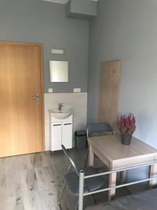 um quarto com uma mesa e cadeiras e uma porta em Lawendowy Hostel Wrocław em Breslávia