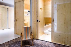マーストリヒトにあるThe Green Elephant Hostel & Spaの木製の壁、椅子、ベッドが備わる客室です。