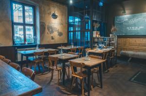 a restaurant with wooden tables and chairs in a room at Hotel Luis in Regensburg