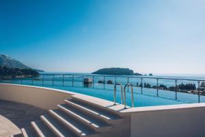 a swimming pool with a view of the ocean at Iberostar Waves Slavija in Budva