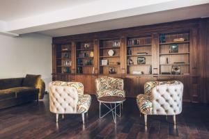 a living room with two chairs and a book shelf at Iberostar Waves Slavija in Budva