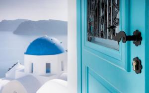 a blue door with a building in the background at Sophia Oia View in Oia