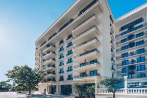 an apartment building with balconies and trees at Iberostar Waves Slavija in Budva