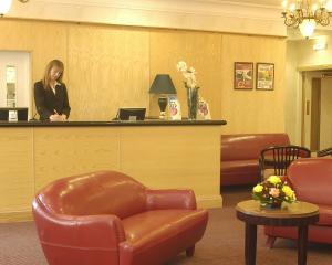 a woman standing at a counter in a waiting room at Britannia Bournemouth Hotel in Bournemouth