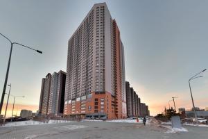 a large tall building with snow in front of it at Highvill Apartments in Astana