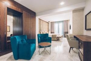 a living room with blue chairs and a table at Iberostar Waves Slavija in Budva
