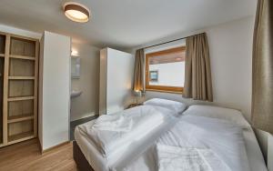 A bed or beds in a room at Glemm Lodge Apartments - JOKER CARD im Sommer inklusive