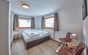 A bed or beds in a room at Glemm Lodge Apartments - JOKER CARD im Sommer inklusive