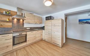 A kitchen or kitchenette at Glemm Lodge Apartments - JOKER CARD im Sommer inklusive