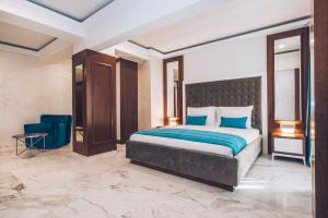 a bedroom with a large bed and a blue blanket at Iberostar Waves Slavija in Budva