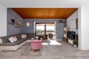 uma sala de estar com um sofá e uma mesa em Apartments Rose em Baska Voda