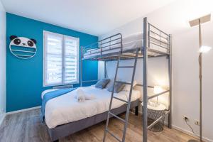 a bedroom with two bunk beds and a blue wall at Panda Suite - Fairytale Factory in Bailly-Romainvilliers