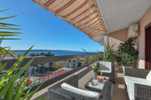 a balcony with chairs and a table with a view at Apartments Rose in Baška Voda