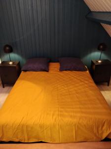 - un grand lit jaune dans une chambre avec 2 tables de chevet dans l'établissement LES JACINTHES, à Berck-sur-Mer