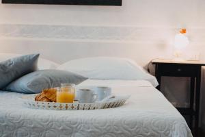 ein Tablett mit Frühstücksspeisen auf einem Bett in der Unterkunft Hotel La Valle dell'Aquila in LʼAquila