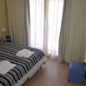 1 dormitorio con 1 cama con 2 toallas en Complejo La Celeste en Playas Doradas