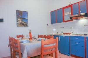 een keuken met een tafel en blauwe kasten bij Apartment Suzy in Vantačići