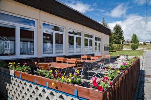 a patio with tables and chairs and flowers outside of a building at KNAUS Campingpark Viechtach in Viechtach