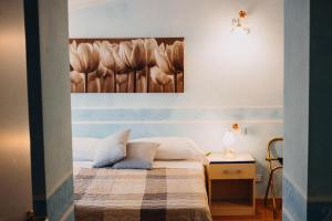 a bedroom with a bed with a painting on the wall at Hotel La Valle dell'Aquila in LʼAquila