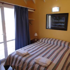 1 dormitorio con 1 cama con 2 toallas en Complejo La Celeste en Playas Doradas