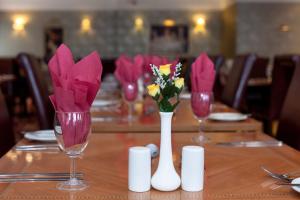 a table with three wine glasses with flowers in them at Heathlands Hotel in Bournemouth