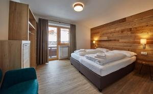 A bed or beds in a room at Glemm Lodge Apartments - JOKER CARD im Sommer inklusive