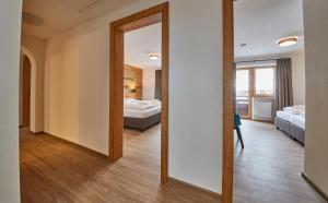 A bed or beds in a room at Glemm Lodge Apartments - JOKER CARD im Sommer inklusive