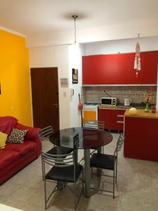 sala de estar con mesa y sofá rojo en Departamento Guly en Villa María